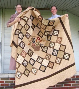 Tammy and Jacquie getting ready to hold up Adam's quilt for photos